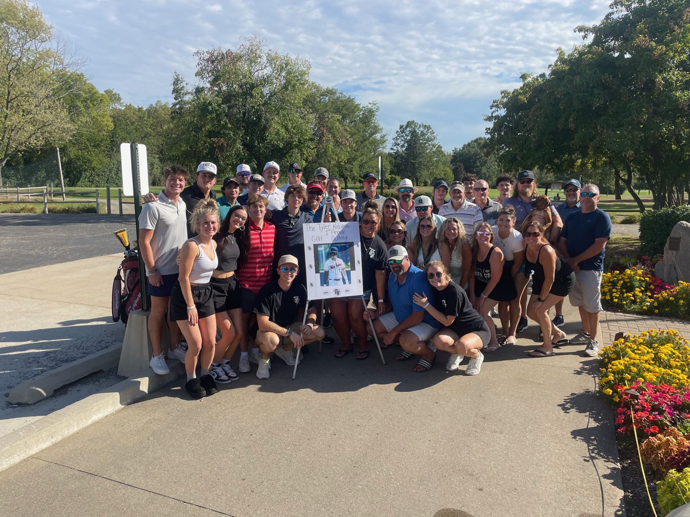 Friends and family gathered around a photo of Tyler at Woodruff Golf Course
